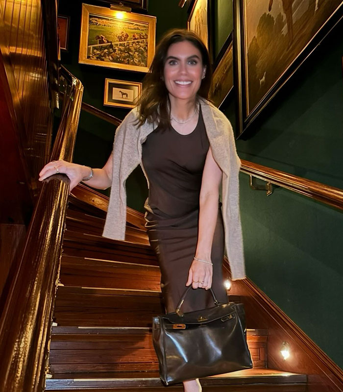 A woman identified as the Green Dress Lady from the Lindsay Clancy trial smiles on a staircase. A woman identified as the Green Dress Lady from the Lindsay Clancy trial smiles on a staircase.