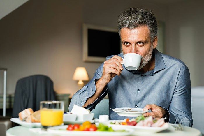 Man drinking coffee during a common breakfast habit, linked to higher mortality risk, especially after age 40. Man drinking coffee during a common breakfast habit, linked to higher mortality risk, especially after age 40.