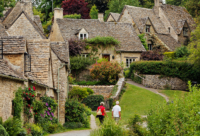 Two tourists walking through the picturesque streets of the world's most beautiful village, enjoying the scenery. Two tourists walking through the picturesque streets of the world's most beautiful village, enjoying the scenery.