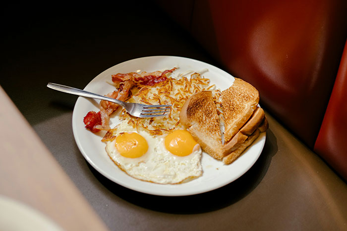 A plate with bacon, eggs, hash browns, and toast, a common breakfast habit linked to higher mortality risk. A plate with bacon, eggs, hash browns, and toast, a common breakfast habit linked to higher mortality risk.