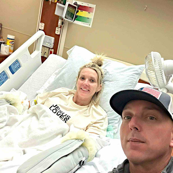 A woman who had both legs and hands amputated after surgery poses with a man in her hospital bed. A woman who had both legs and hands amputated after surgery poses with a man in her hospital bed.