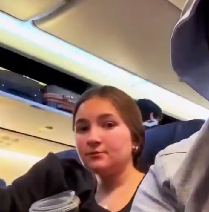 Family flying to surprise daughter, capturing their journey on the plane.