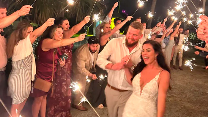 A newlywed bride and groom celebrate at their wedding surrounded by guests with sparklers, before the bride's life was taken. A newlywed bride and groom celebrate at their wedding surrounded by guests with sparklers, before the bride's life was taken.