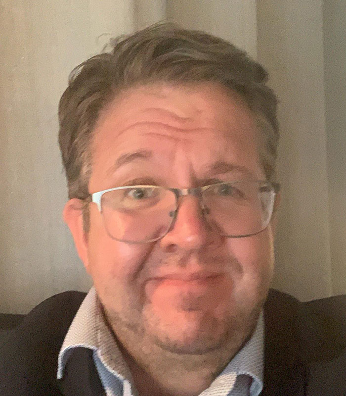 A man wearing glasses, representing the surgeon involved in the amputation and horrific crimes.