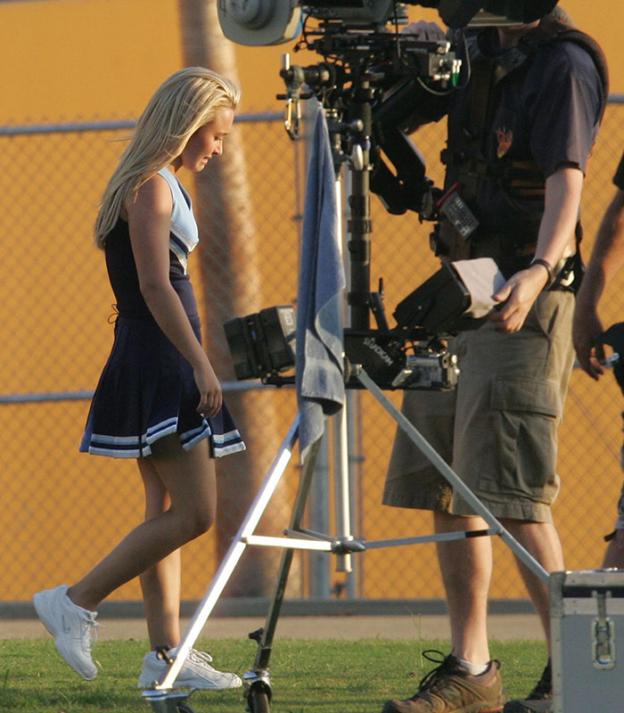 Hayden Panettiere in a cheerleader uniform, walking past camera equipment. An extra worked with her under not-so-great conditions. Hayden Panettiere in a cheerleader uniform, walking past camera equipment. An extra worked with her under not-so-great conditions.