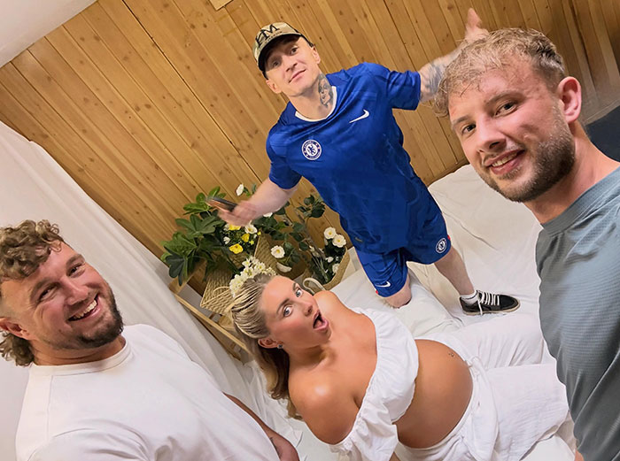 Bonnie Blue with two men at her raunchy baby shower, lying on a white sheet.