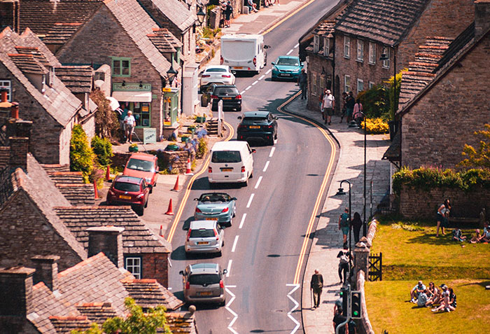 An aerial view of a busy street in the world's most beautiful village, filled with cars and tourists. An aerial view of a busy street in the world's most beautiful village, filled with cars and tourists.