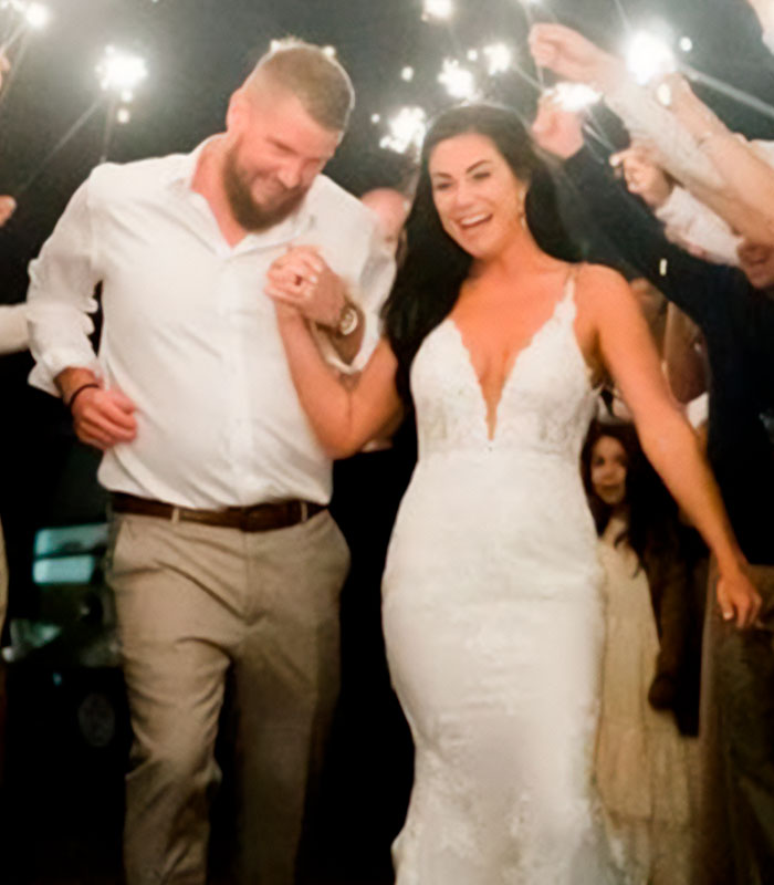 A bride and groom celebrating their wedding day, walking hand-in-hand surrounded by sparklers, before the tragic incident involving a drunk woman. A bride and groom celebrating their wedding day, walking hand-in-hand surrounded by sparklers, before the tragic incident involving a drunk woman.