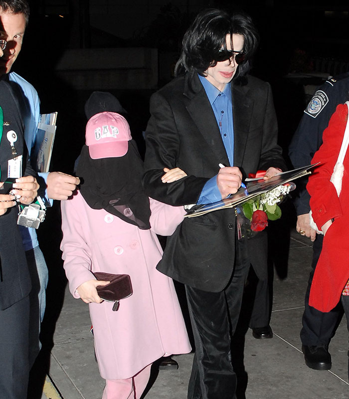 Michael Jackson signing autographs with a child, discussing life and disturbing accusations. Michael Jackson signing autographs with a child, discussing life and disturbing accusations.
