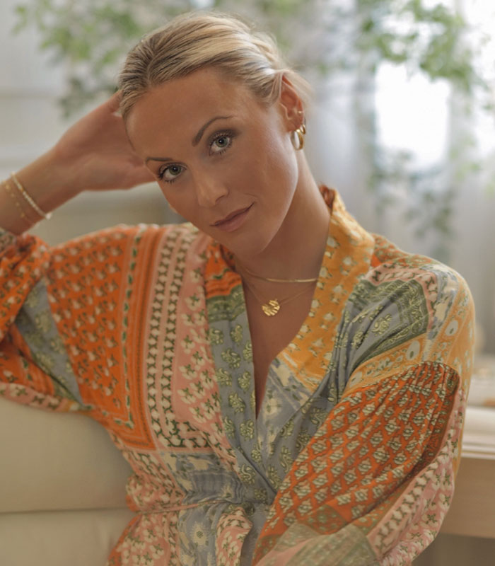 Blonde influencer with hair pulled back, wearing a colorful patterned top, part of 11 influencers exposed for lying