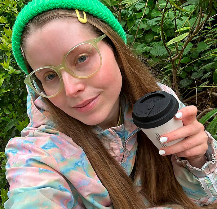 Harry Potter star smiling with a coffee cup outdoors. Harry Potter star smiling with a coffee cup outdoors.