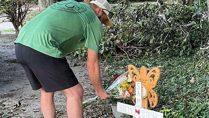 Man placing flowers at a memorial after the woman took the bride's life on wedding day. Man placing flowers at a memorial after the woman took the bride's life on wedding day.