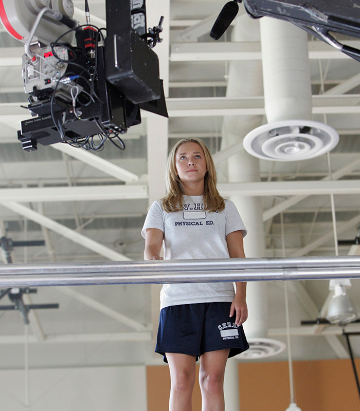 Hayden Panettiere on set in a gym, wearing a physical ed t-shirt. An extra reveals her behavior under not-so-great conditions. Hayden Panettiere on set in a gym, wearing a physical ed t-shirt. An extra reveals her behavior under not-so-great conditions.