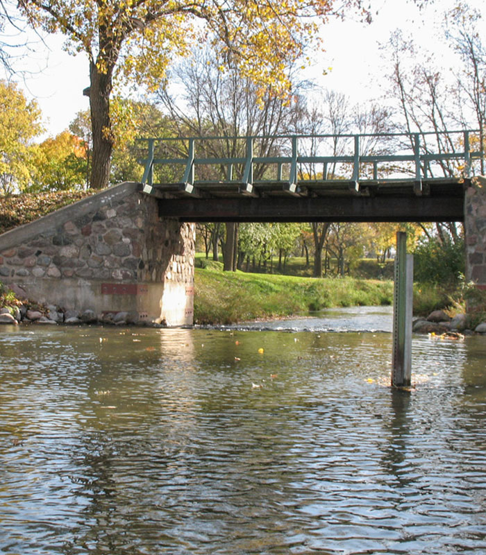 A bridge over a river, near where a car crashed into a ditch, leading to unexplained events.