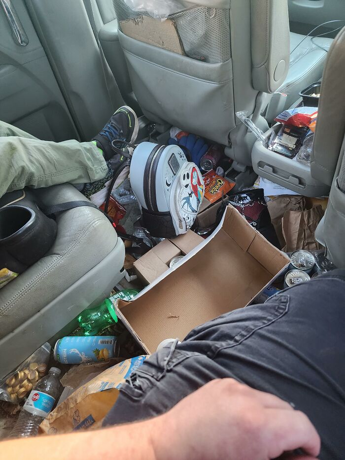 An extremely messy car interior, illustrating a parent's wrong way to maintain their vehicle.