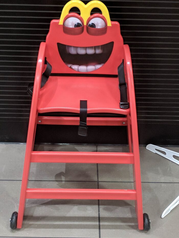 A frightening red high chair resembling a McDonald's character, a design fail that is impressive in its own way.