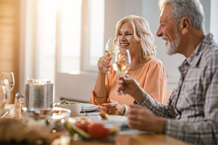 A happy couple enjoying dinner, potentially with new dinner buddies, facing the realization about paying bills. A happy couple enjoying dinner, potentially with new dinner buddies, facing the realization about paying bills.
