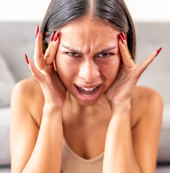 A woman expressing anger and frustration, likely after an entitled woman demands a photographer honor a promise.