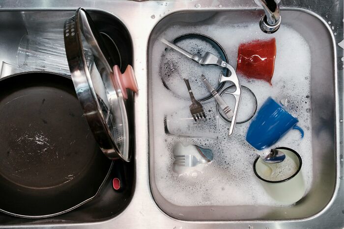 A kitchen sink full of dirty dishes and soapy water, reflecting a truth about being married.