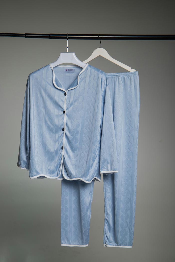 A light blue pajama set with white trim, hanging on a rack, representing dumb work rules.