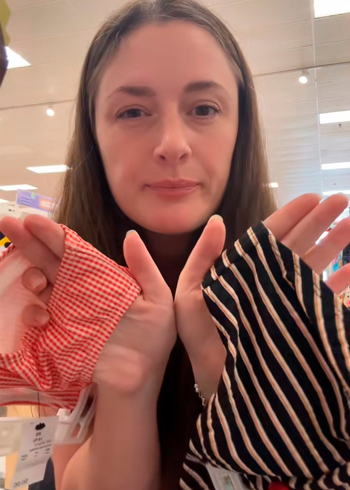 A girl mom holds up two pieces of kids clothing, highlighting a concerning trend for back-to-school shoppers. A girl mom holds up two pieces of kids clothing, highlighting a concerning trend for back-to-school shoppers.