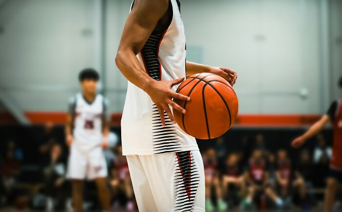 College life: A basketball player holding a ball, highlighting the sports and freedom experienced in college.