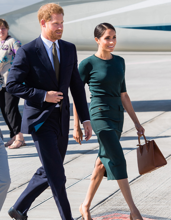 Prince Harry and Meghan Markle walking, possibly related to financial aid for their UK move. Prince Harry and Meghan Markle walking, possibly related to financial aid for their UK move.