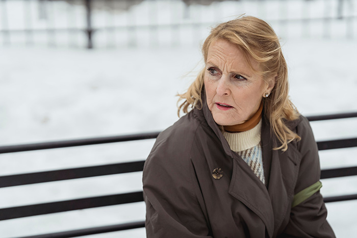 A woman with a concerned expression, illustrating the stress of a MIL's invasive accusations after giving birth.
