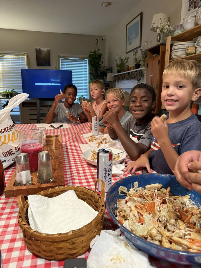 Joyful adopted kids, part of a large family, gather around a table for a meal, symbolizing a loving family. Joyful adopted kids, part of a large family, gather around a table for a meal, symbolizing a loving family.