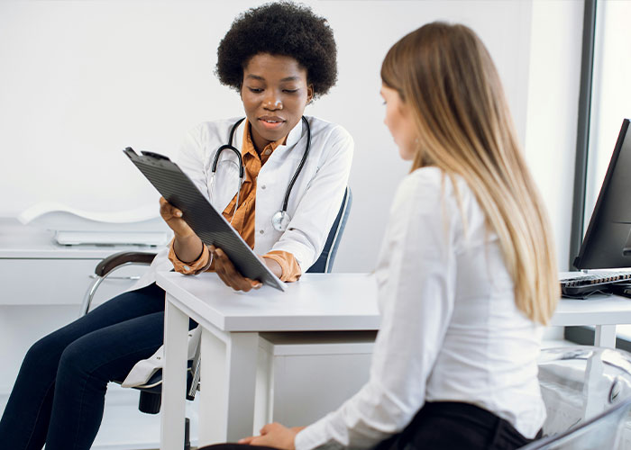 Doctor consulting a woman about perimenopause symptoms and overlooked health issues.