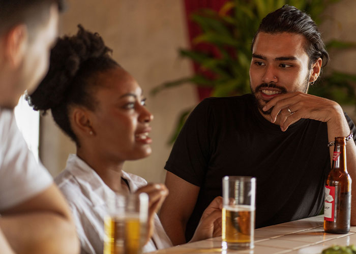 A group of friends enjoys drinks, discussing their worst first dates with women.