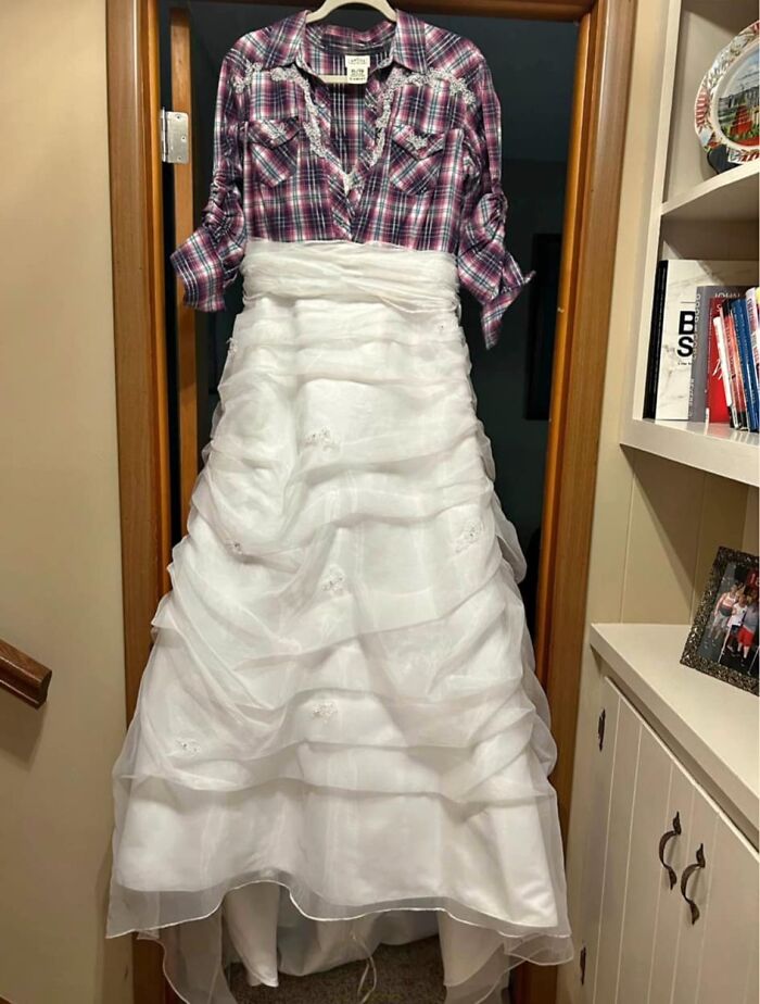 A white wedding dress is paired with a plaid shirt, a hilariously bad fashion crime, hanging on a door.