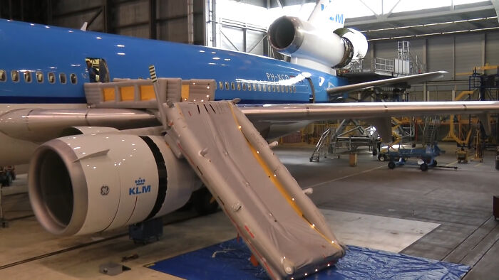 An inflatable emergency slide deployed from a large blue airplane, highlighting cabin crew and their experiences.