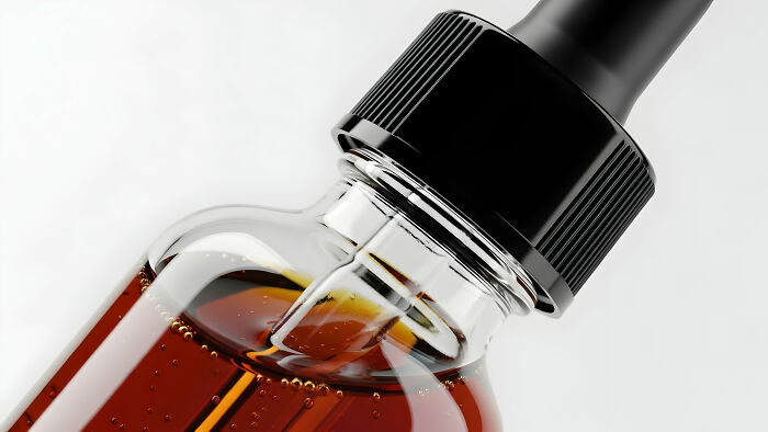A close-up of a dropper bottle containing amber liquid, highlighting common healthy habits people question.