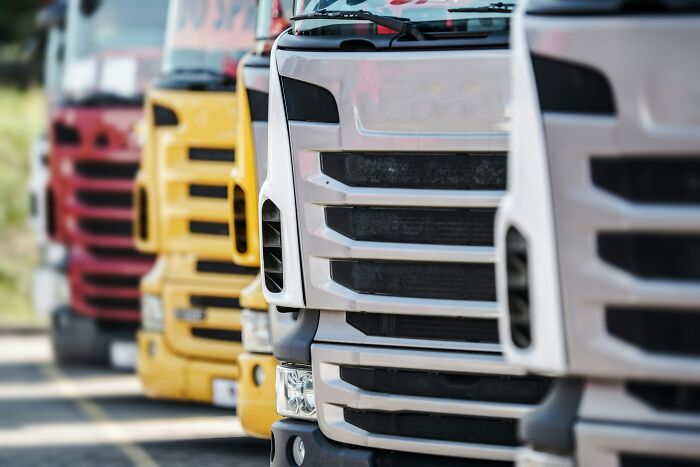 A line of semi-trucks, illustrating industry secrets of logistics and transportation.