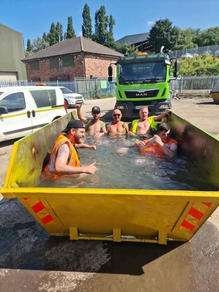 Eastern Europe men built different, cooling off in a skip filled with water on a sunny day.