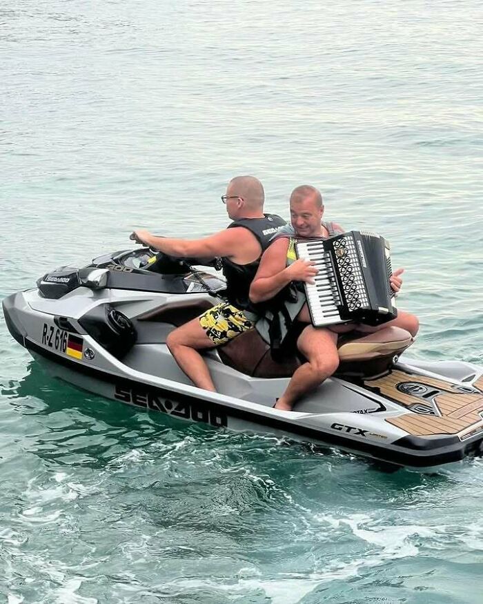 Eastern Europe men built different, playing an accordion on a jet ski in the middle of the sea.
