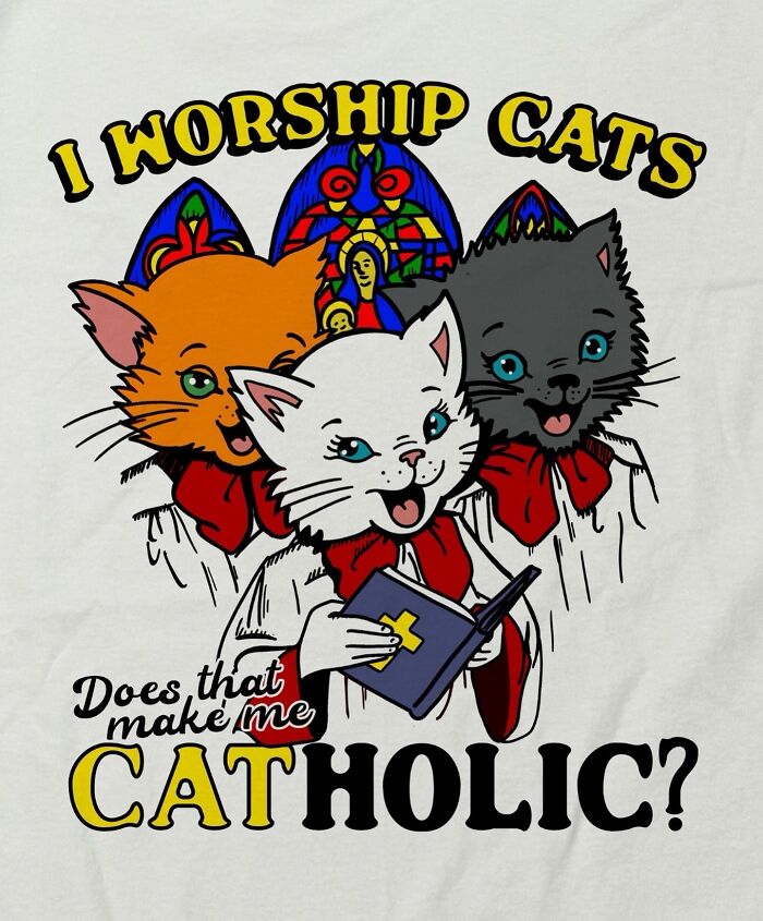 An iconic shirt featuring three cartoon cats in choir robes with stained glass backgrounds, saying 'I worship cats. Does that make me Catholic?'