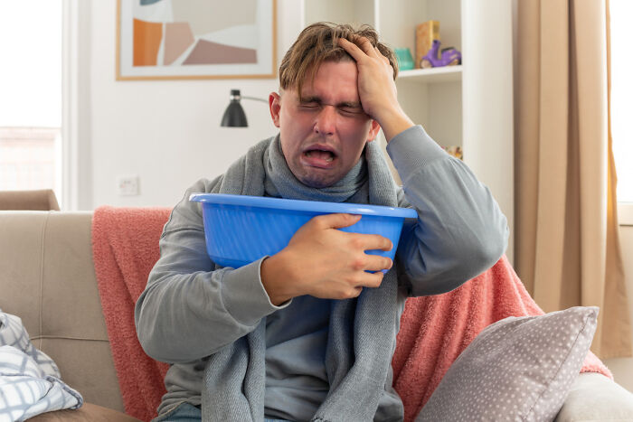 A man looking ill, holding a basin, depicting challenging stories from life.