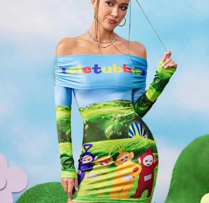 A woman wears a Teletubbies-themed off-the-shoulder dress, a hilariously bad fashion crime, with a landscape background.