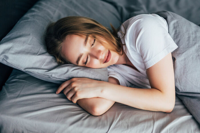 Woman peacefully sleeping in bed, a serene image related to the line between life and what comes after.
