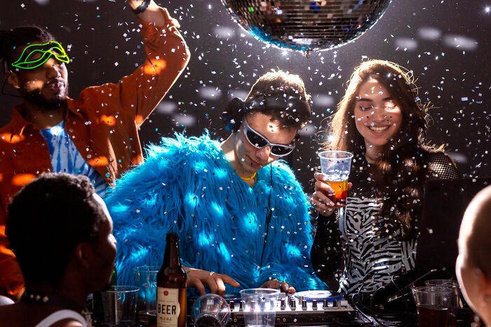 People partying under a disco ball with confetti, one person in a blue furry coat, highlighting dumb reasons couples divorce.