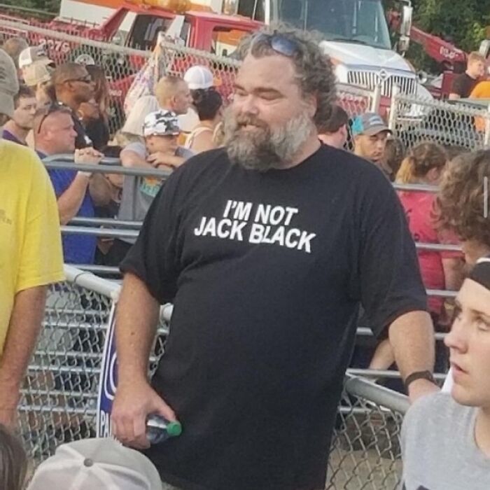 Iconic shirts: A bearded man in a crowd wearing a black t-shirt that says, 'I'M NOT JACK BLACK'.