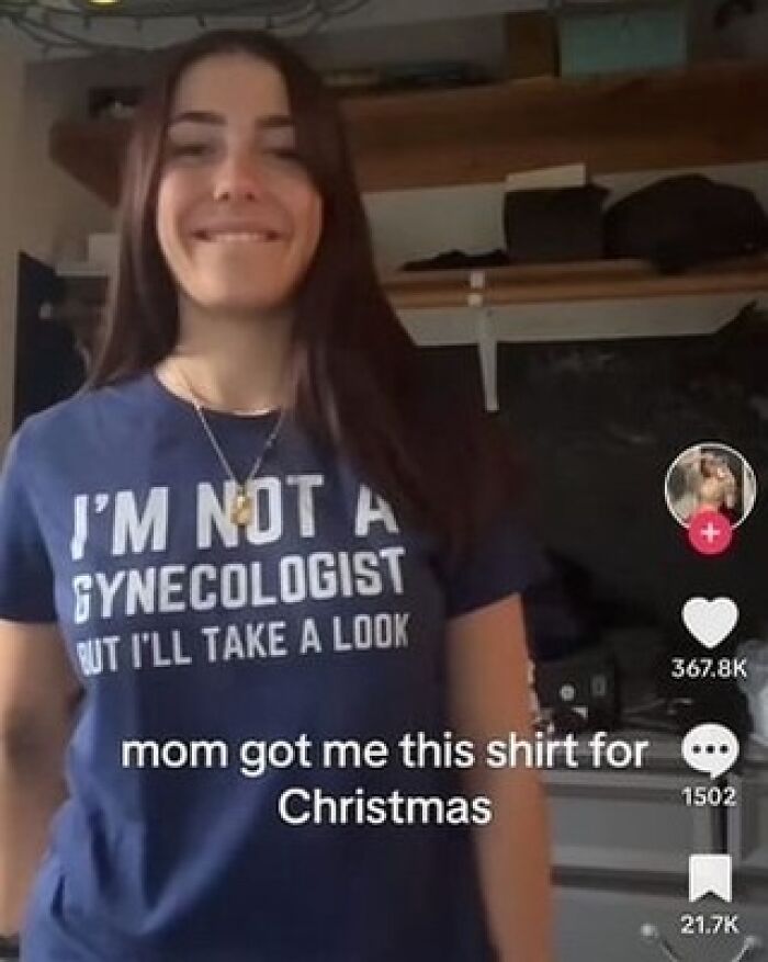 Iconic shirts: Young woman smiling, wearing a blue t-shirt that says, 'I'M NOT A GYNECOLOGIST BUT I'LL TAKE A LOOK.'