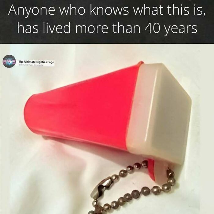 A small, red plastic whistle with a metal chain, a nostalgic item from the 80s.