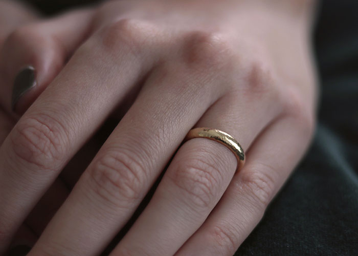 A close-up of a hand wearing a simple gold ring, hinting at relationship outcomes from first dates.