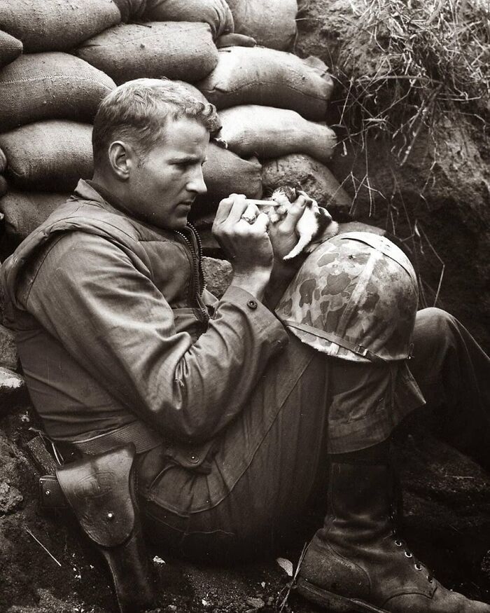 Vintage photo of a soldier feeding a small animal, showing animals have always stolen the spotlight.