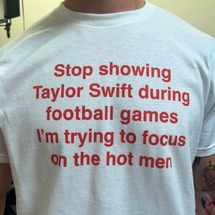 A white shirt with red text that says, 'Stop showing Taylor Swift during football games I'm trying to focus on the hot men', an iconic shirt.
