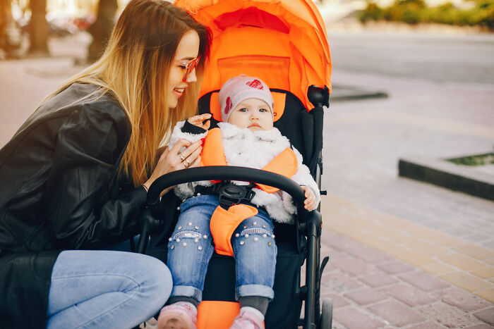Mother and child in a stroller, demonstrating a lifestyle choice or poverty habit.