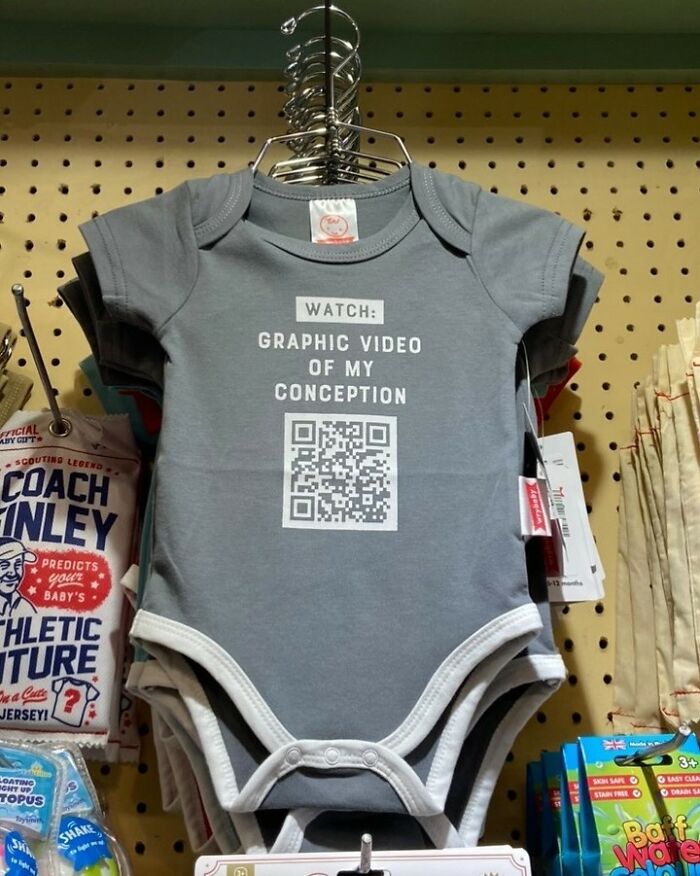 A baby onesie with a QR code and the text 'WATCH: GRAPHIC VIDEO OF MY CONCEPTION', one of many iconic shirts.